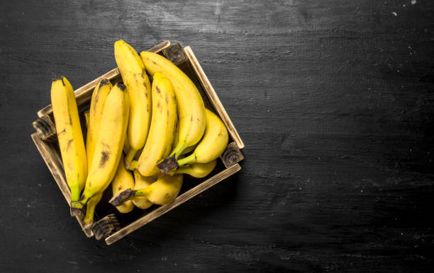 istock Ripe bananas in an old box. 900569056