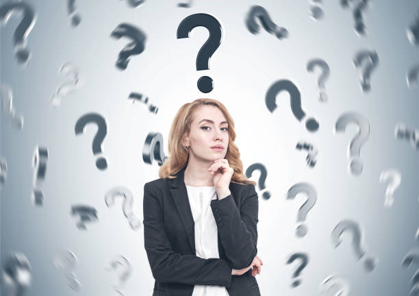 istock Pensive red haired businesswoman, question marks 900569596