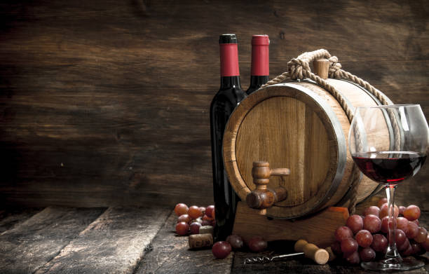 istock Wine background. A barrel with red wine and freshly grapes. 900572556