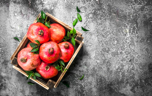 istock Ripe pomegranates in a box. 900572722