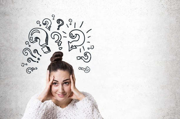 istock Stressed young woman with a bun, question marks 900572948