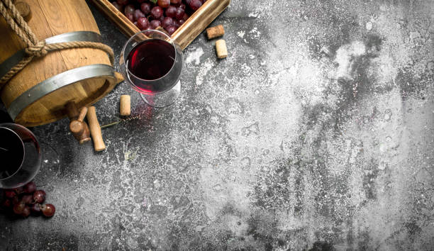 istock Wine background. A barrel with red wine and fresh grapes. 900572966