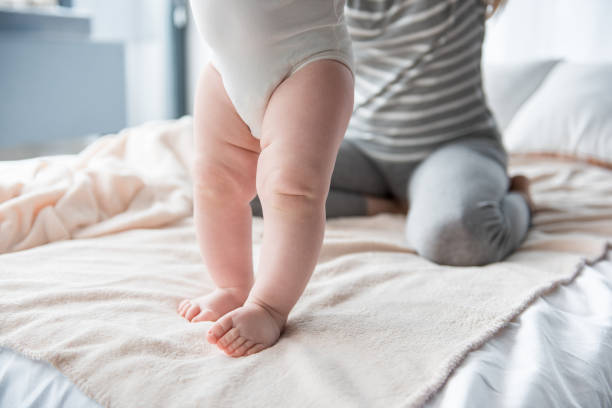 jovem mãe ensinando sua filha em pé - baby cheerful child blanket - fotografias e filmes do acervo