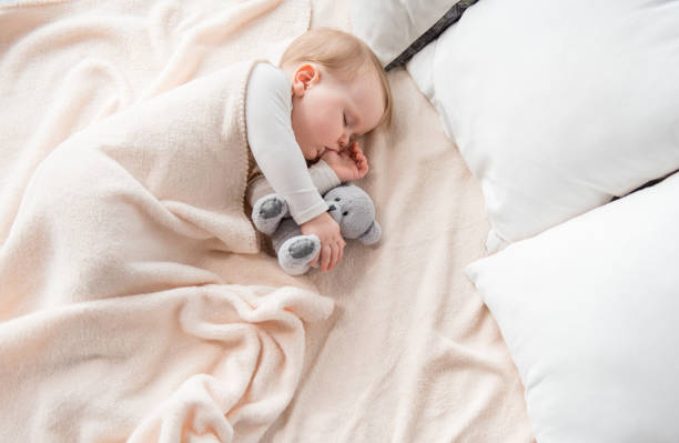 bambino tranquillo che sogna con un bel giocattolo - sleeping baby foto e immagini stock