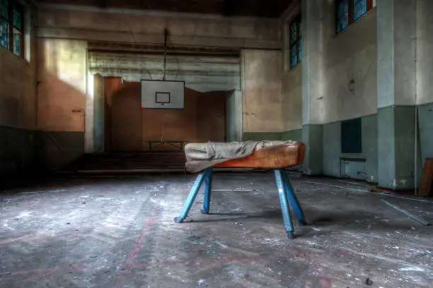 Abandoned sports hall with a pommel horse apparatus in an abandoned school