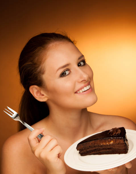 istock chocolate cake - glamorous woman eats dessert 900592536