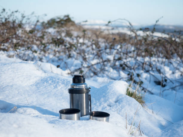 istock Tea Flask with Two Cups in the Snow 900595900