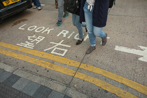Hong Kong, China - December 30, 2017: Traffic warning sign at floor - pedestrian crosswalk at street; Kowloon peninsula, Hong Kong;