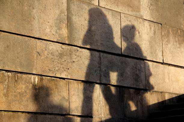 istock mother and son’s shadows on a wall 900607054
