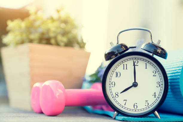 istock Time for exercising clock and dumbbell on the table 900607380