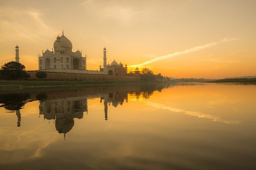 Taj Mahal seen from Yamuna River at dusk with its reflection in the water