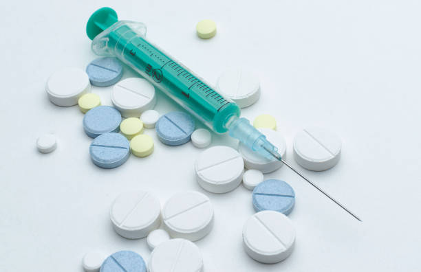 istock colorful tablet and disposable syringe on white background, closeup 900618114