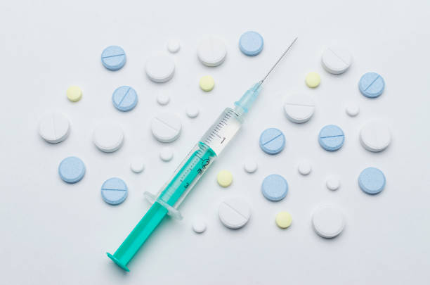 istock colorful tablet and disposable syringe on white background, closeup 900618158
