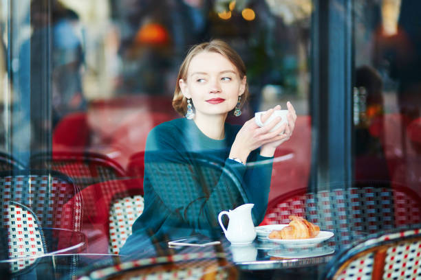 파리, 프랑스에 있는 카페에서 커피를 마시는 젊은 우아한 여자 - cafe breakfast coffee croissant 뉴스 사진 이미지