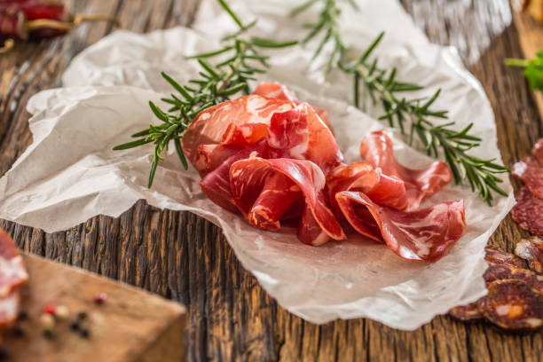 コッパ ・ ディ ・ パルマ生ハム新鮮なローズマリー。地中海料理。イタリア料理 - prosciutto di parma ストックフォトと画像