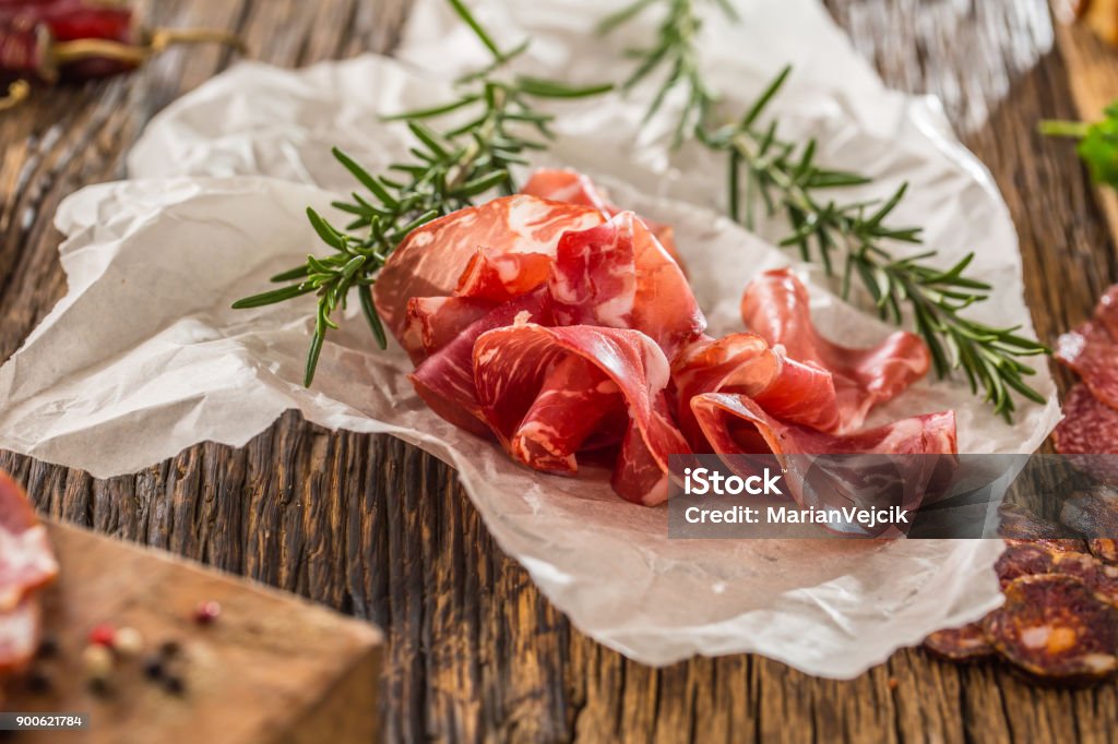 Coppa di Parma ham with fresh rosemary. Mediterranean food.Italian cuisine Coppa di Parma ham with fresh rosemary. Mediterranean food.Italian cuisine. Parma Ham Stock Photo