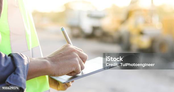 Asiatische Ingenieur Mit Bauarbeiterhelm Mit Tablet Pc Computer Prüfen Und Arbeiten Auf Der Baustelle Stockfoto und mehr Bilder von Baustelle