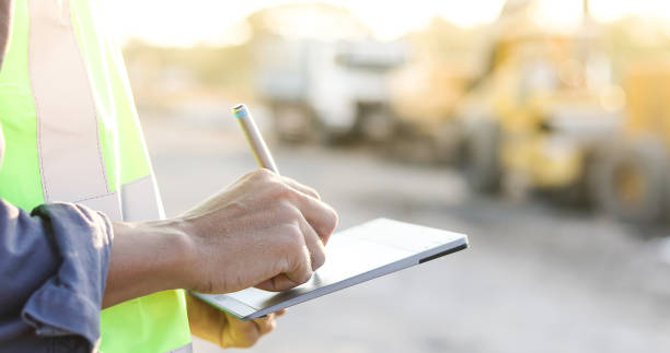 azjatycki inżynier z hardhat za pomocą komputera typu tablet kontroli komputera i pracy na placu budowy - crane mobile crane derrick crane construction vehicle zdjęcia i obrazy z banku zdjęć