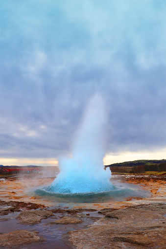 Strokkur Gesyer in Iceland - vertical image of an erupting geyser at dusk