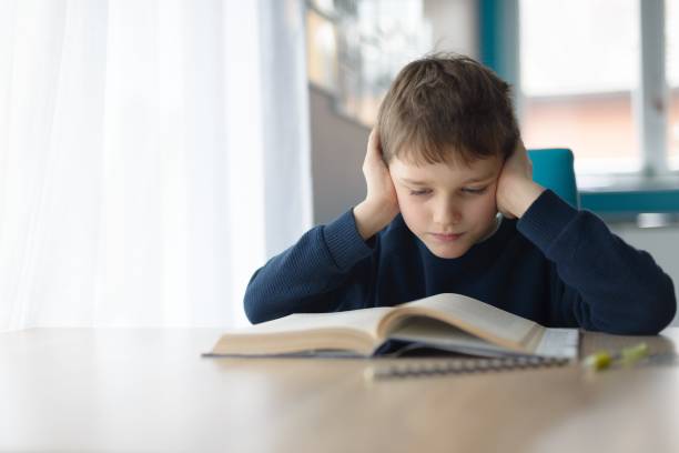 istock Child reading a book at the desk 900636212