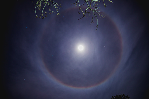 New Years eve, Novi Sad, Serbia 31.12.2017. Circular rainbow around the Moon, also known as a Moonbow, lunar halo, or lunar rainbow, caused by the refraction of light through ice particles in high altitude clouds. A large ring or circle of light around the moon is called a 22-degree halo by scientists.