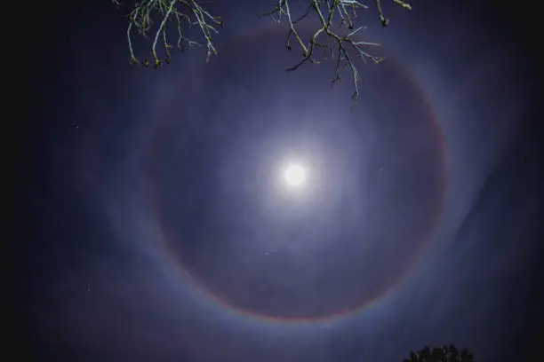 New Years eve, Novi Sad, Serbia 31.12.2017. Circular rainbow around the Moon, also known as a Moonbow, lunar halo, or lunar rainbow, caused by the refraction of light through ice particles in high altitude clouds. A large ring or circle of light around the moon is called a 22-degree halo by scientists.
