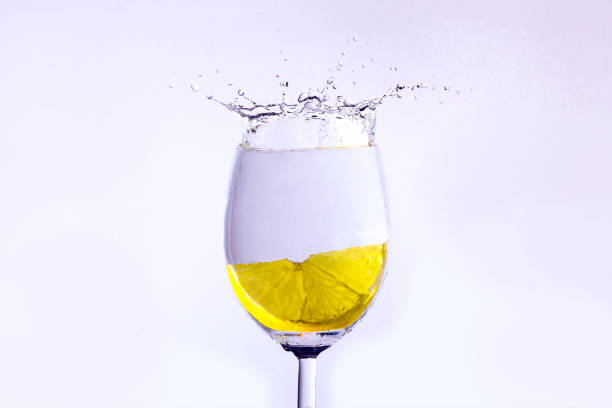 레몬 조각 보드카와 유리에 빠진다. 거품과 밝아진 표시 - gin tonic water martini olive 뉴스 사진 이미지