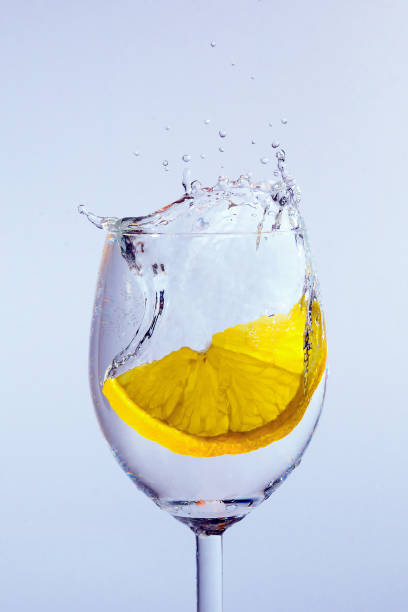 레몬 조각 보드카와 유리에 빠진다. 거품과 밝아진 표시 - gin tonic water martini olive 뉴스 사진 이미지