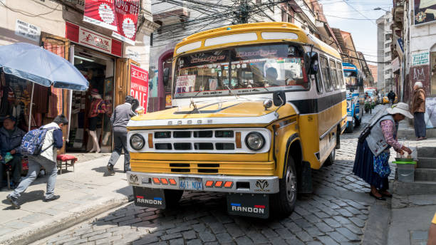 public transport bus go down a street with few pedestrians walking by, la paz, bolivia - bustrip imagens e fotografias de stock