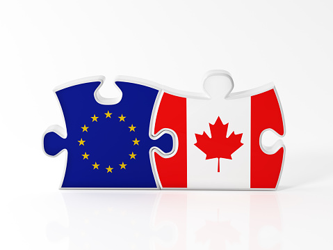 Jigsaw puzzle pieces textured with European Union and Canadian flags on white. Horizontal composition with copy space. Clipping path is included.