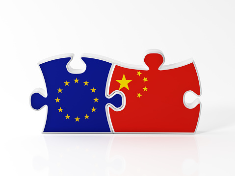 Jigsaw puzzle pieces textured with European Union and Chinese flags on white. Horizontal composition with copy space. Clipping path is included.