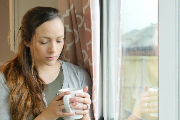 istock Sad depressed woman drinking morning coffee at home 900664800