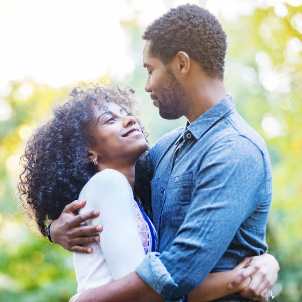 istock Young couple embraces outside in the sunlight 900665028