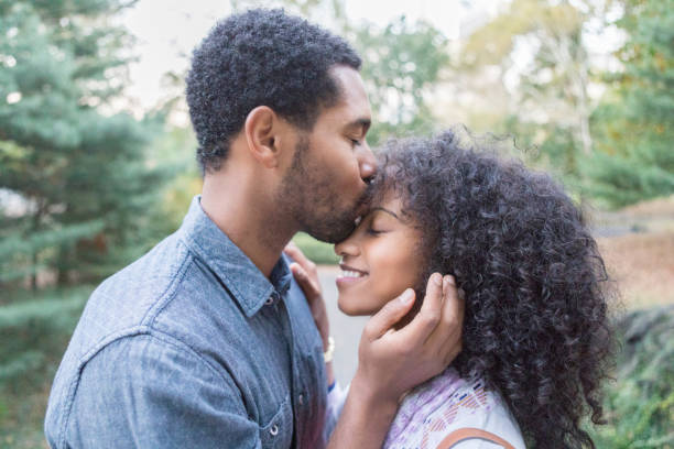 giovane coppia abbraccia e bacia fuori - adult autumn couple face to face foto e immagini stock