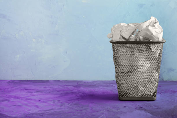 istock A trash can for paper. Beautiful unusual background with place for text. A full trash can for paper sheets. 900665254