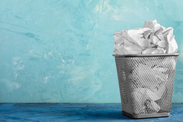 istock A trash can for paper. Beautiful background with place for text. A full trash can for crumpled paper sheets. 900665270