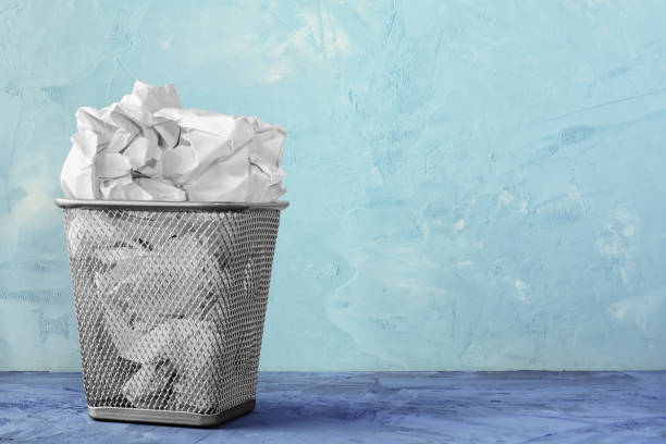 istock A trash can for paper. Beautiful background with place for text. A full trash can for crumpled paper sheets. 900674130