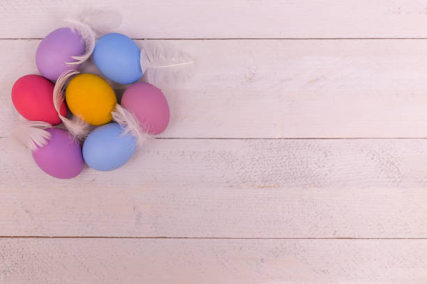 istock colorful Easter eggs on a white wooden board 900702670