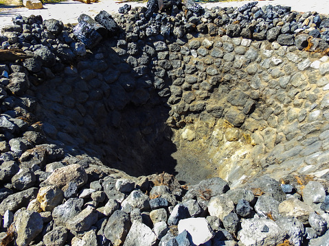 Dirt oven with volcanic rocks for cooking Mezcal
