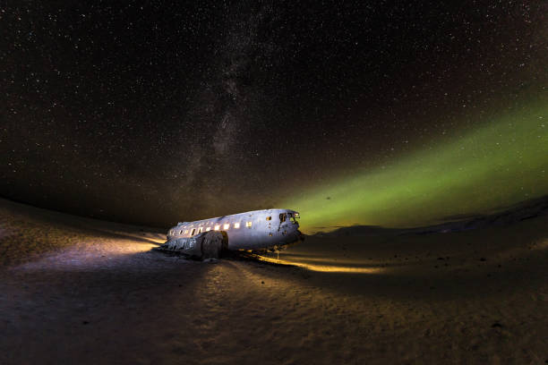 istock Solheimasandur plane wreck with active norhtern lights, Iceland 900703230