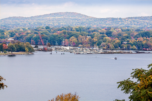 Landscape with Trees in Autumn Colors (Foliage), Hudson River, Sailboats moored at Hudson Valley Marine (Montrose, NY) and Cloudy Blue Sky, Hudson Valley, New York. This image was taken from Stony Point Battlefield State Historic Site. Canon EOS 6D (full frame sensor). Polarizing filter.