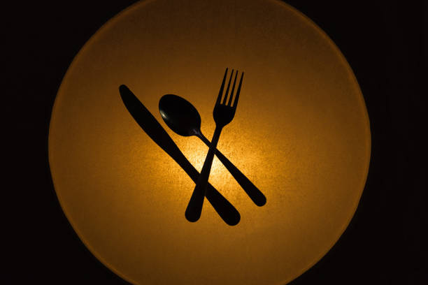 Silver fork, knife and spoon on the black background. Top view. Copy space. Close-up.