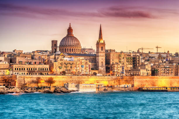 Valletta, Malta: skyline from Marsans Harbour at sunset Valletta, Malta: skyline from Marsans Harbour at sunset. The cathedral malta stock pictures, royalty-free photos & images