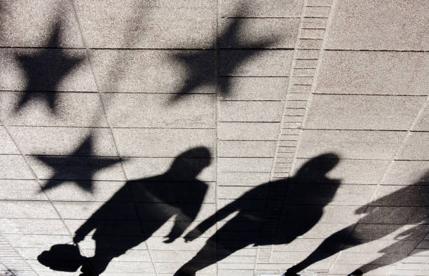 istock Shadow silhouette of people on city sidewalk 900722632