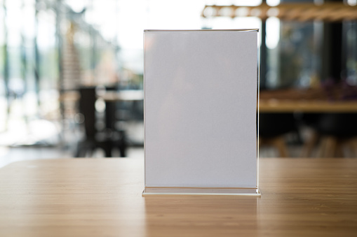white label in cafe. display stand for acrylic tent card in coffee shop. mockup menu frame on table in bar restaurant. space for text