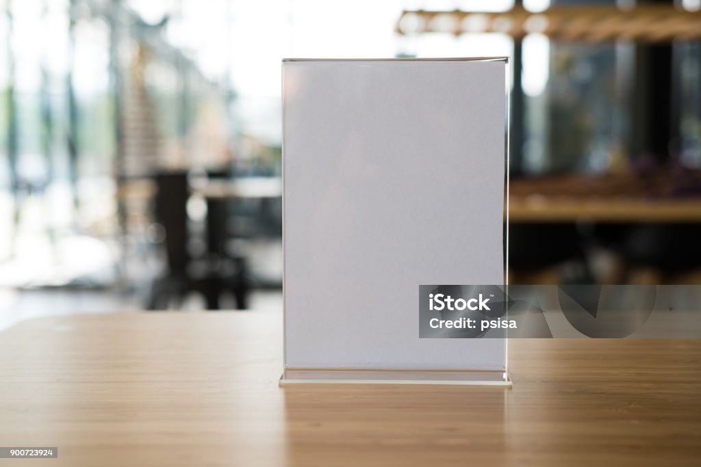 white label in cafe. display stand for acrylic tent card in coffee shop. mockup menu frame on table in bar restaurant. white label in cafe. display stand for acrylic tent card in coffee shop. mockup menu frame on table in bar restaurant. space for text Retail Display Stock Photo