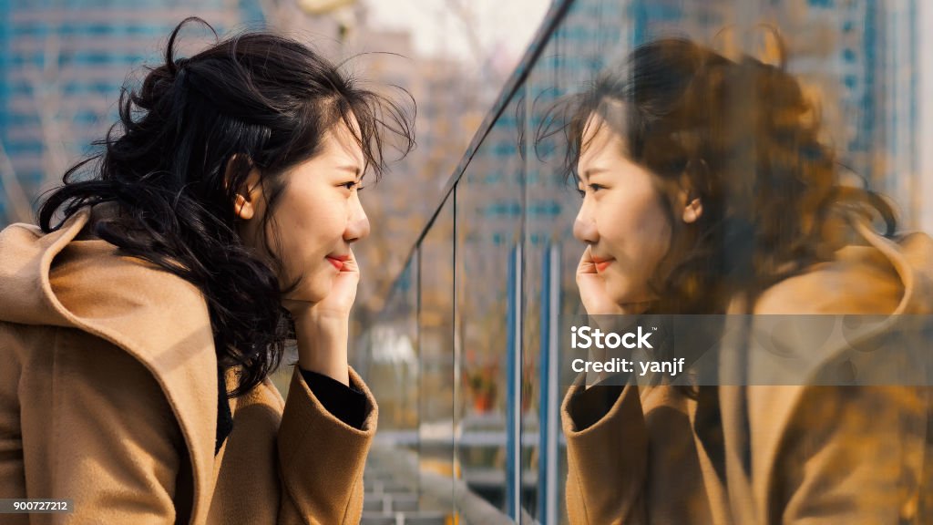 ガラスの彼女の鏡像を見て美しい中国の女の子。 - 鏡のロイヤリティフリーストックフォト
