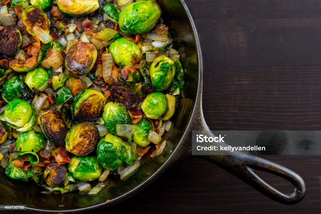 Diagonal Cast Iron Skillet with Brussels Sprouts Diagonal Cast Iron Skillet with Brussels Sprouts over dark table top Brussels Sprout Stock Photo