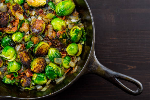 Diagonal Cast Iron Skillet with Brussels Sprouts Diagonal Cast Iron Skillet with Brussels Sprouts over dark table top brussels sprout stock pictures, royalty-free photos & images