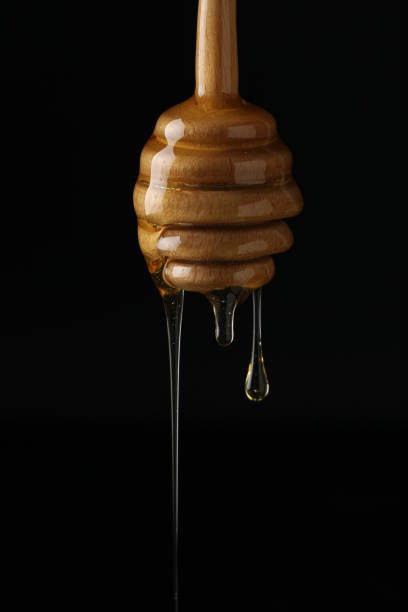 Honey dripping from a wooden honey dipper